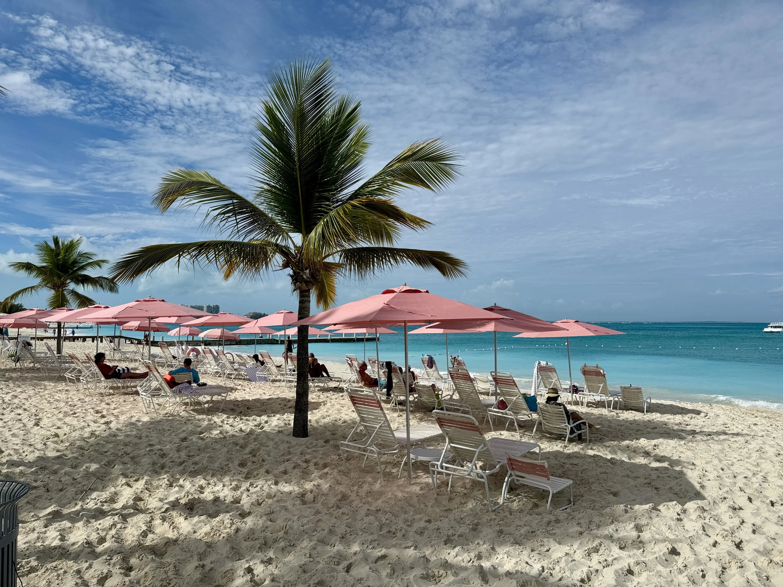 Beach chairs and coral umbrellas at Ocean Club West on Grace Bay in Turks and Caicos