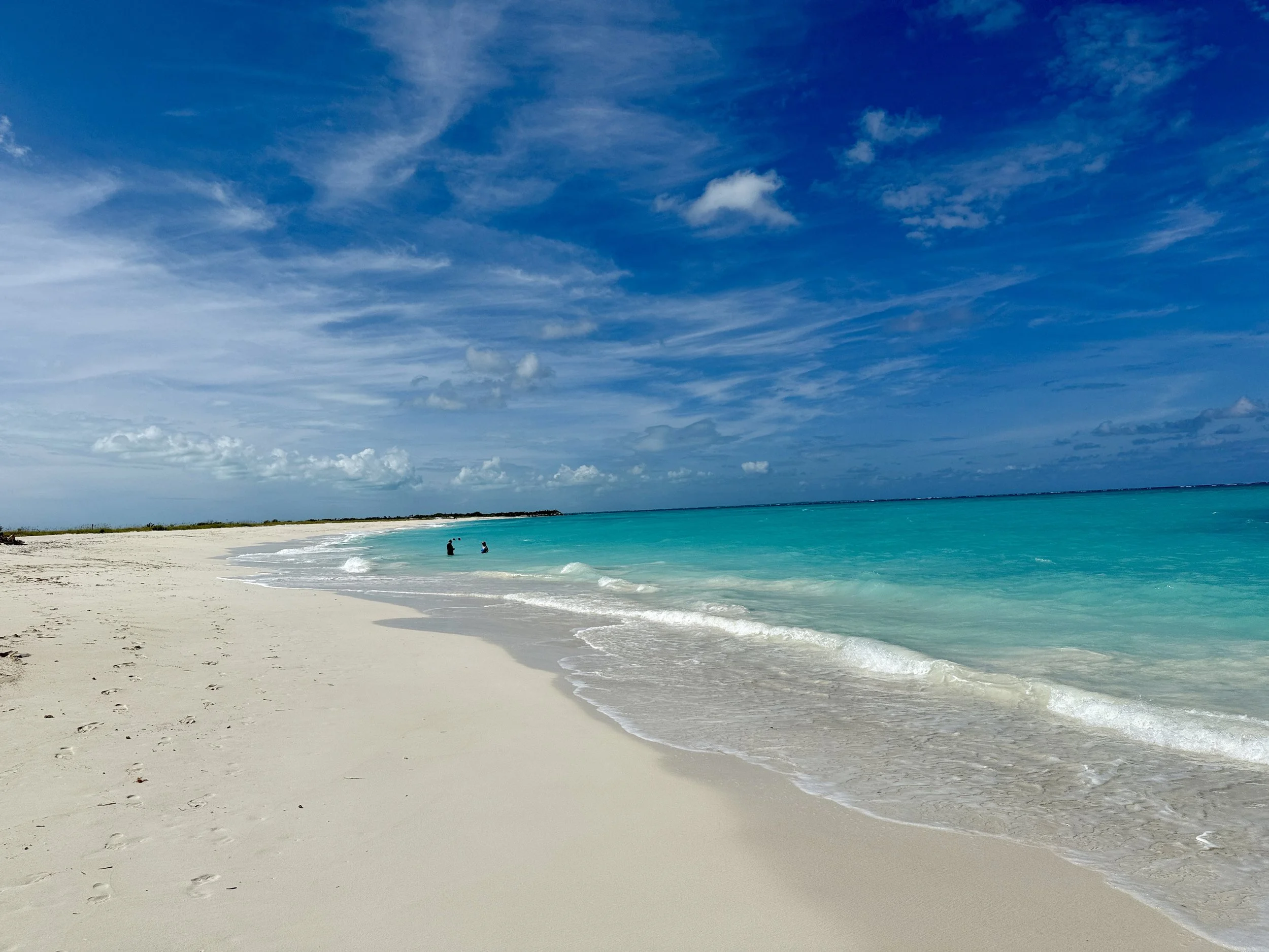 White sand shoreline on Grace Bay in Turks and Caicos with vibrant turquoise water and blue sky