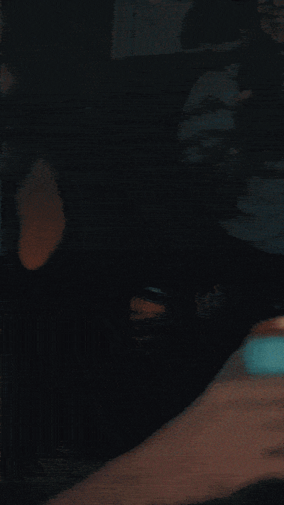 A close-up of a person’s face with makeup, showing blue eyeshadow, eyeliner, and a hand with painted nails near the face.