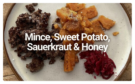 A plate with minced meat, sweet potato chunks, sauerkraut, and honey, labeled as Mince, Sweet Potato, Sauerkraut & Honey.