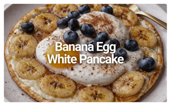Banana egg white pancake topped with blueberries, a dollop of whipped cream, and sprinkled with cinnamon.