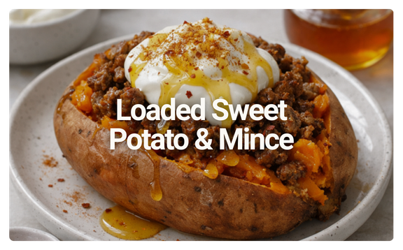 Loaded sweet potato and mince on a plate with sour cream and spices.