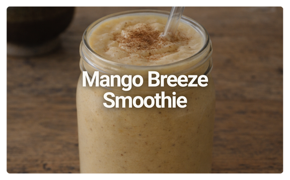 A Mango Breeze Smoothie in a glass jar with a straw on a wooden surface.