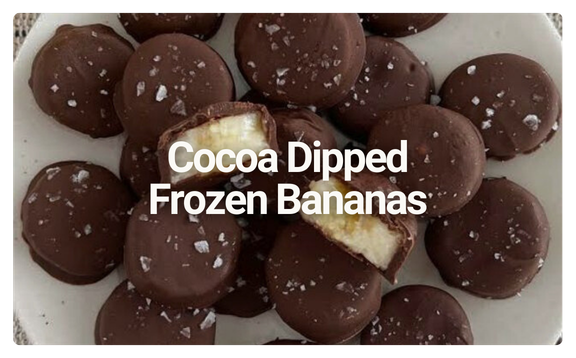 Chocolate-covered frozen bananas with a salted topping, one cut in half showing the banana inside.