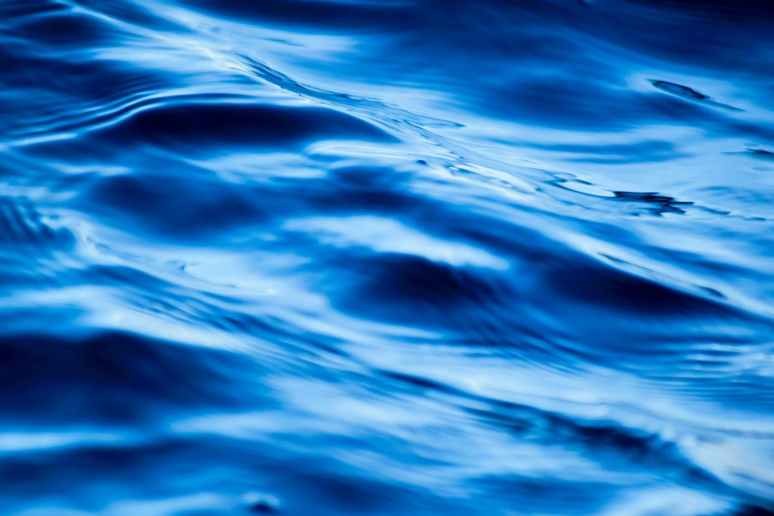 Close-up of the surface of blue ocean water with gentle ripples.
