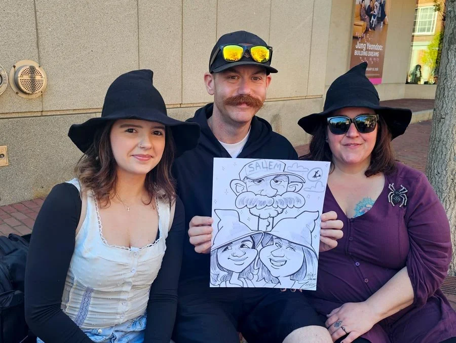 A man with a large mustache holds his caricature with his sister, mom, and himself.