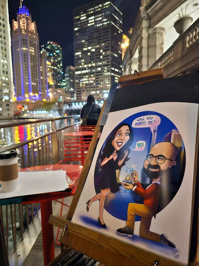A pre-made digital caricature of a man proposing to a woman is on an easel with the Chicago river and towers in the background.