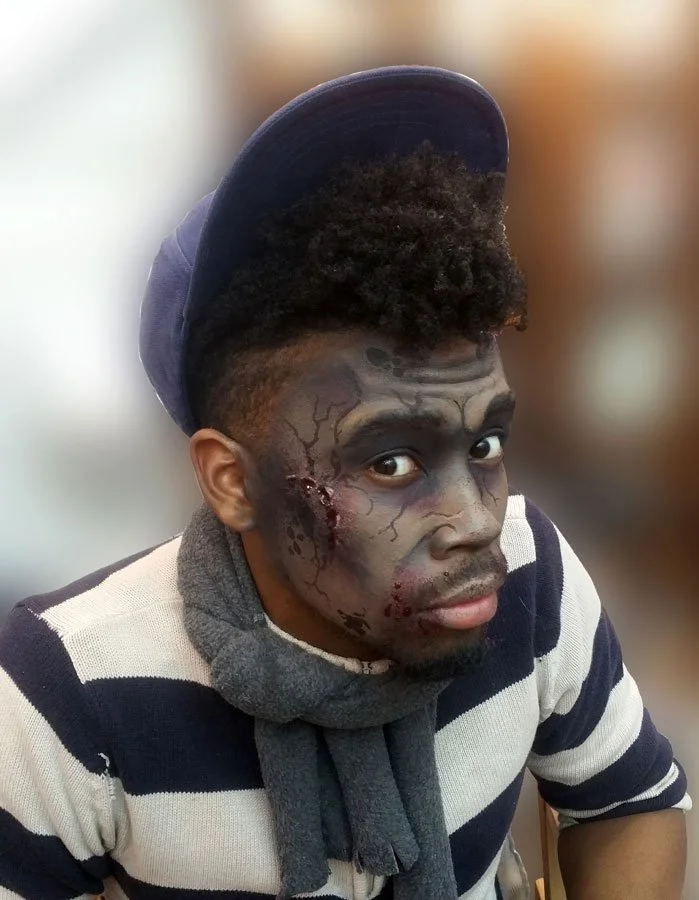 A man shows off his zombie face paint.