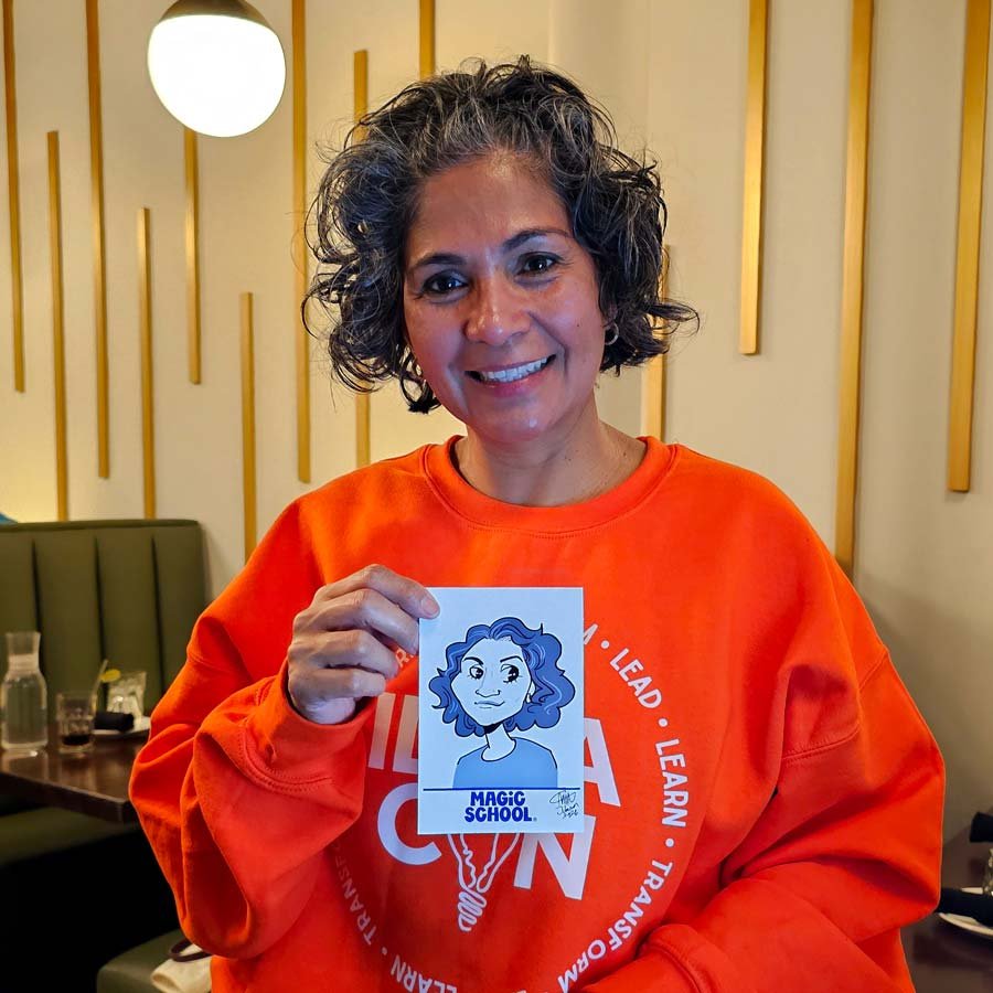 A woman in a bright orange sweater holds her digital caricature print.