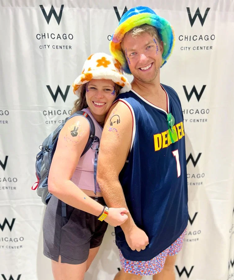 Couple dressed for a music festival shows off their temporary tattoos on their arms.