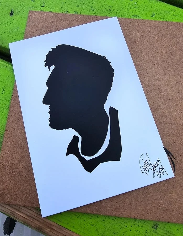 A silhouette of a man on top of brown cutting board and bright green table.