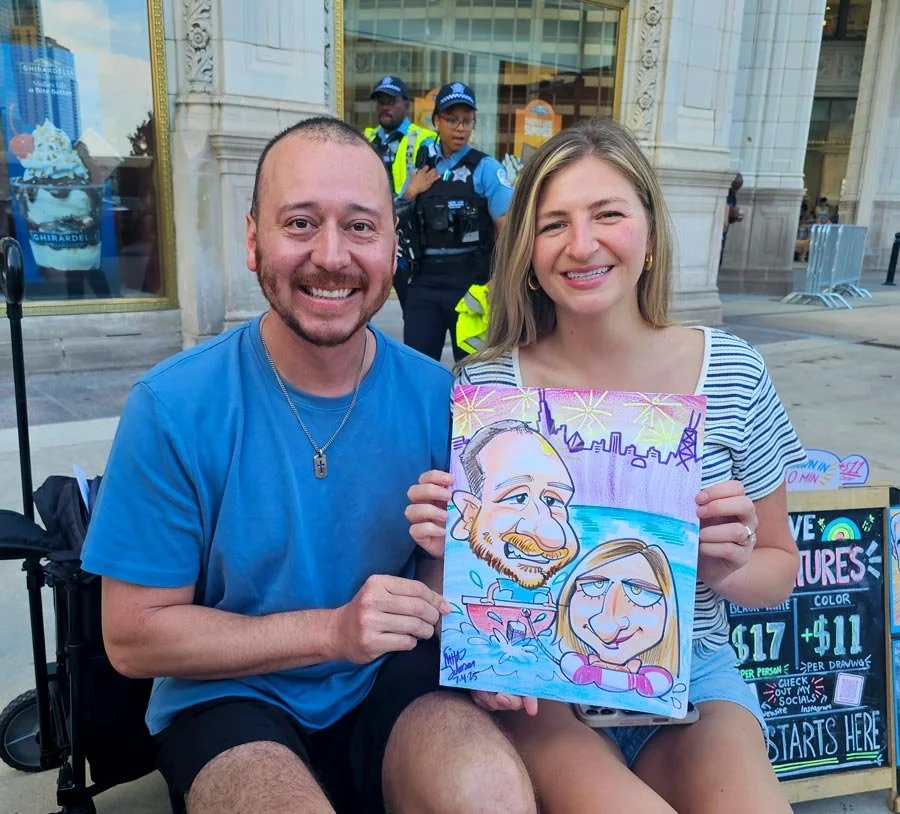 Laughing couple sitting in a plaza holds of their color caricature of the man in a boat and the woman stuck in a life ring in the water.