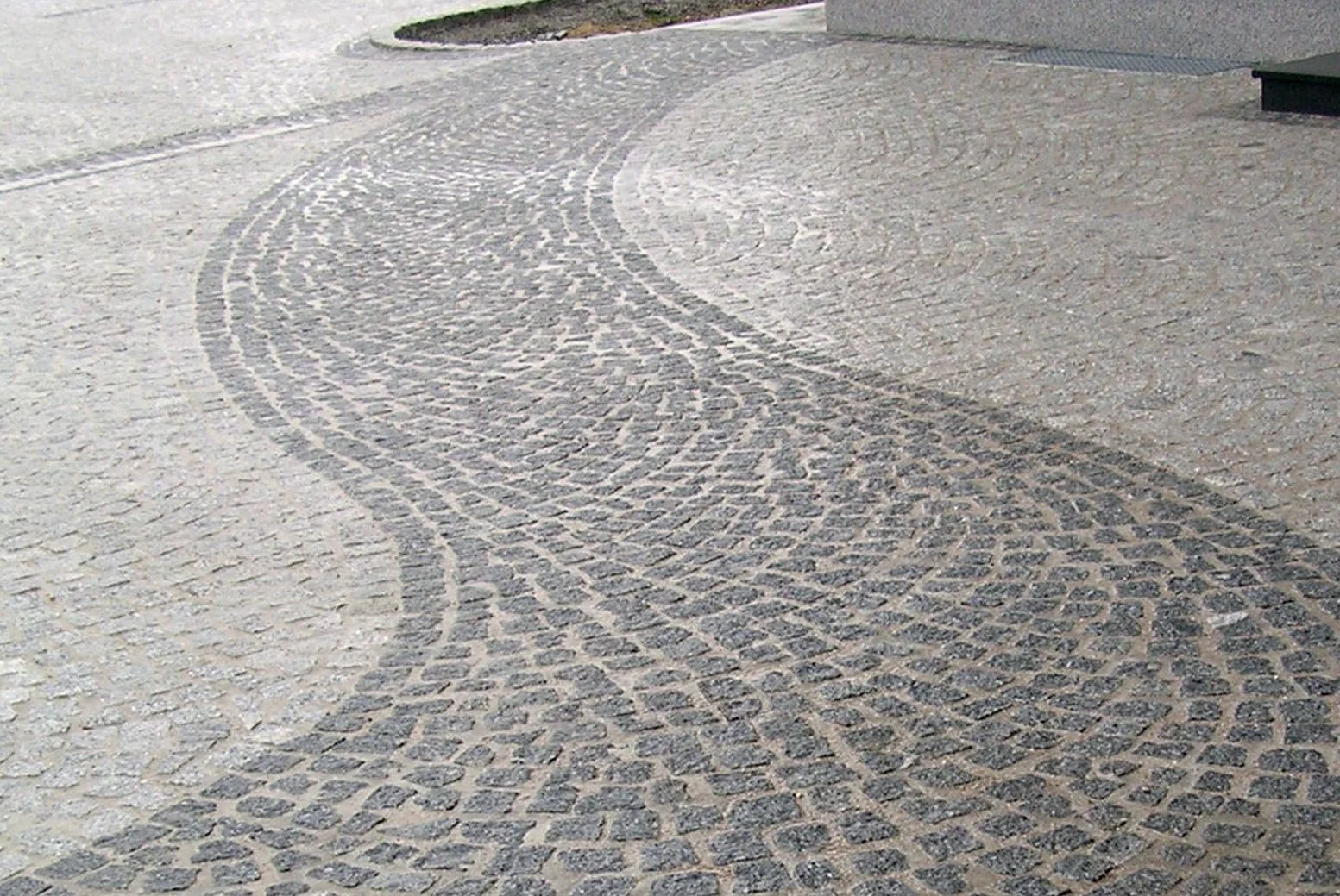 Boden mit geschwungenen Mustern aus dunklen und hellen Steinen