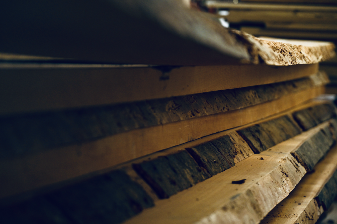 Mehrere Holzbohlen in verschiedenen Größen und Texturen gestapelt.