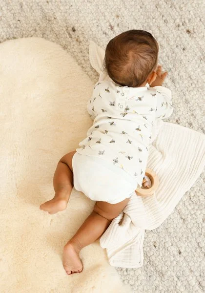 Baby in beigem Strampler im Studio – natürliche Modefotografie für den Waschbär-Katalog