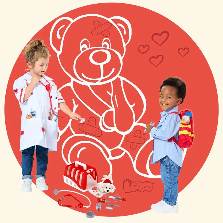 Zwei Kinder als Ärzte verkleidet spielen vor einem großen roten Herz mit einem großen Teddybär, der mit Verbandsstreifen und Herzchen illustriert ist, sowie Spiel-Ärztetaschen und medizinisches Spielzeug.
