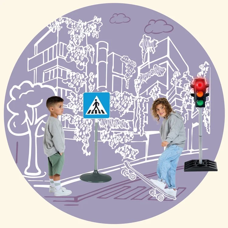 Zwei Kinder am Zebrastreifen mit Verkehrsampel und Schulwegzeichen vor einer grafischen Stadtwand