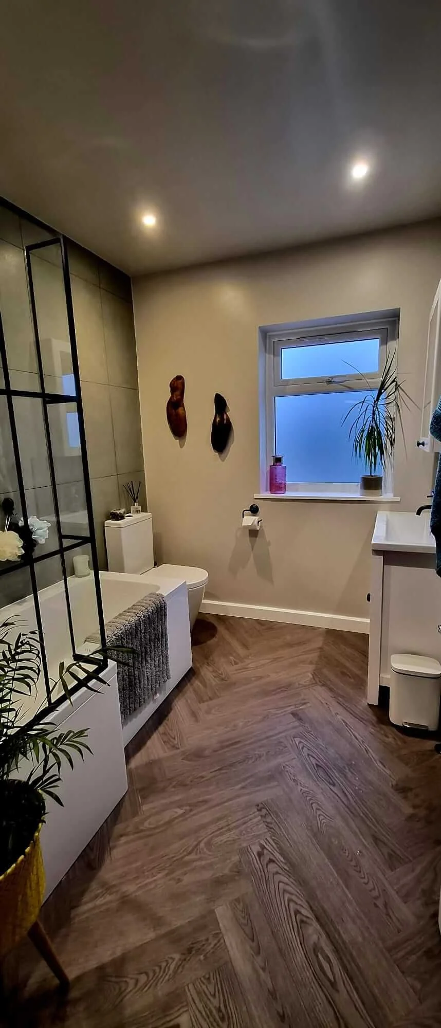 Finished modern bathroom renovation in Ashton, Bristol BS3, featuring updated sanitary ware, tiled walls, LVT flooring and an L-shaped bath with shower screen.