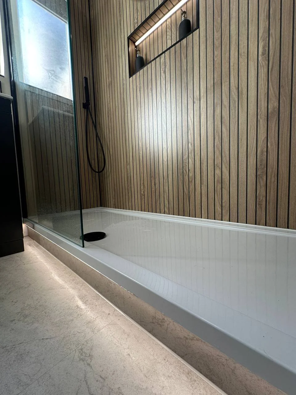 LED lighting washing across LVT flooring beneath shower in Bath bathroom