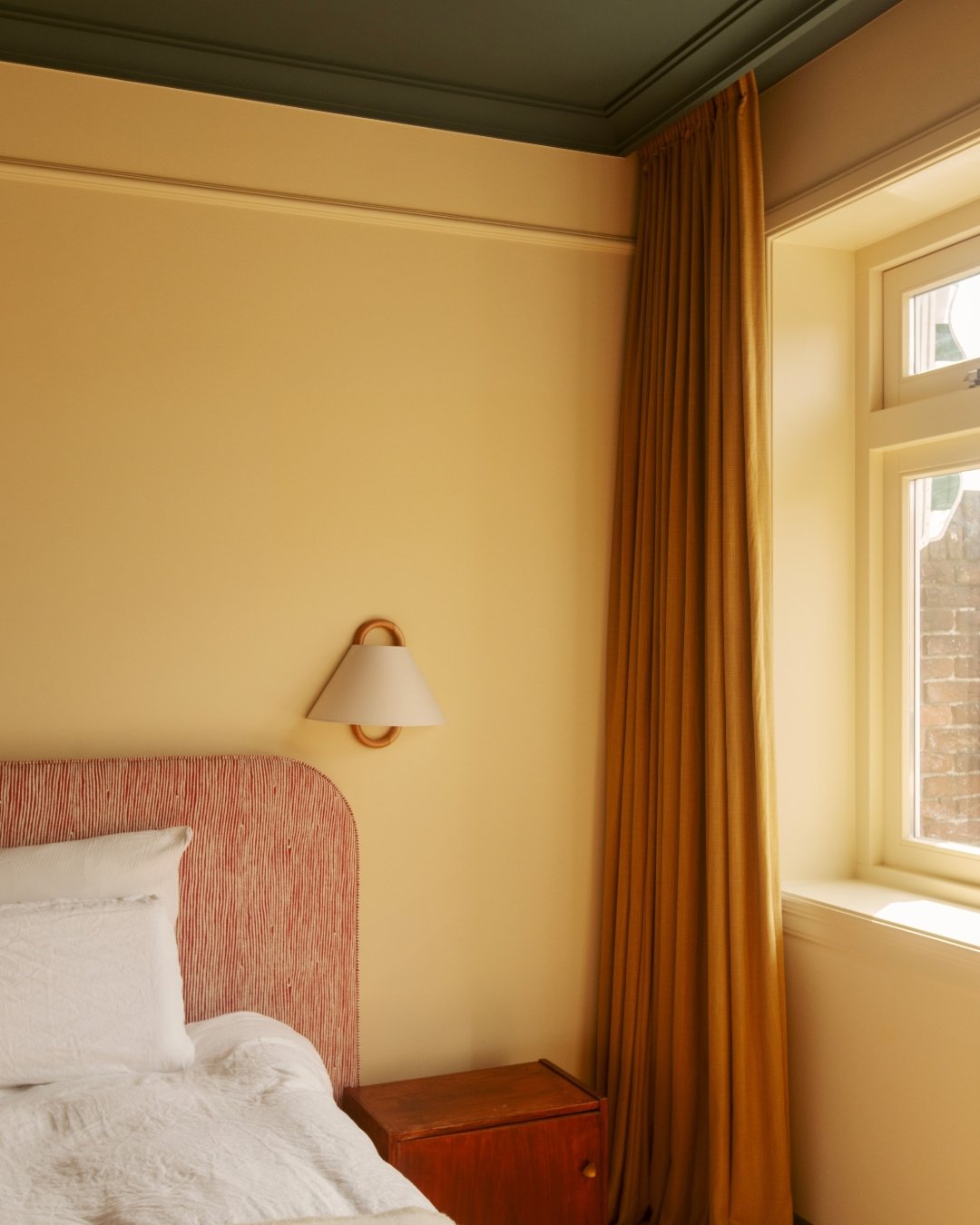 A sophisticated light yellow hue and a striking dark ceiling. The subtle graphic print and round shapes create a calm yet unique ambiance that speaks volumes.