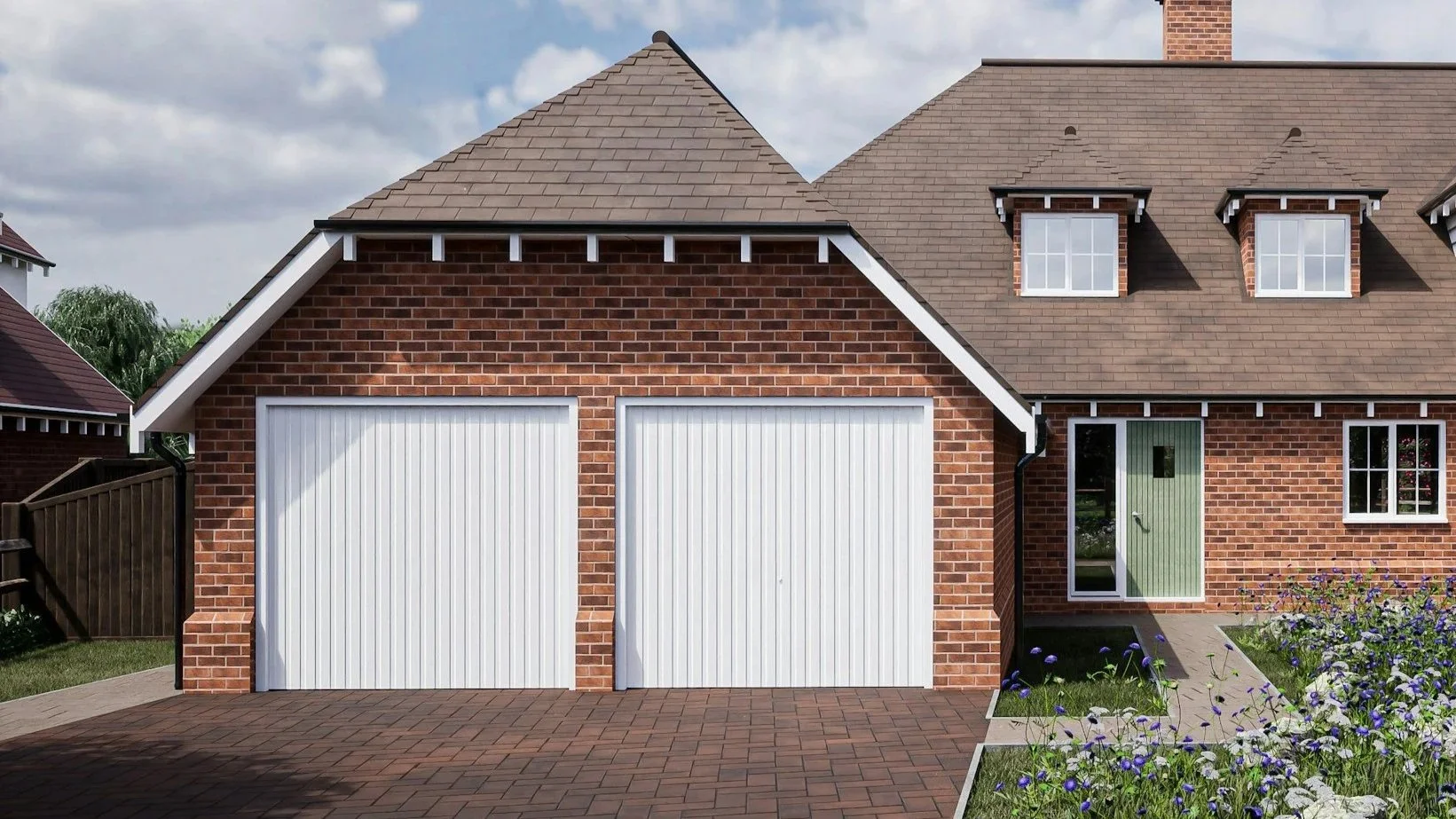A brick house with a brown roof, white garage doors, and a green front door, surrounded by garden with purple and white flowers.