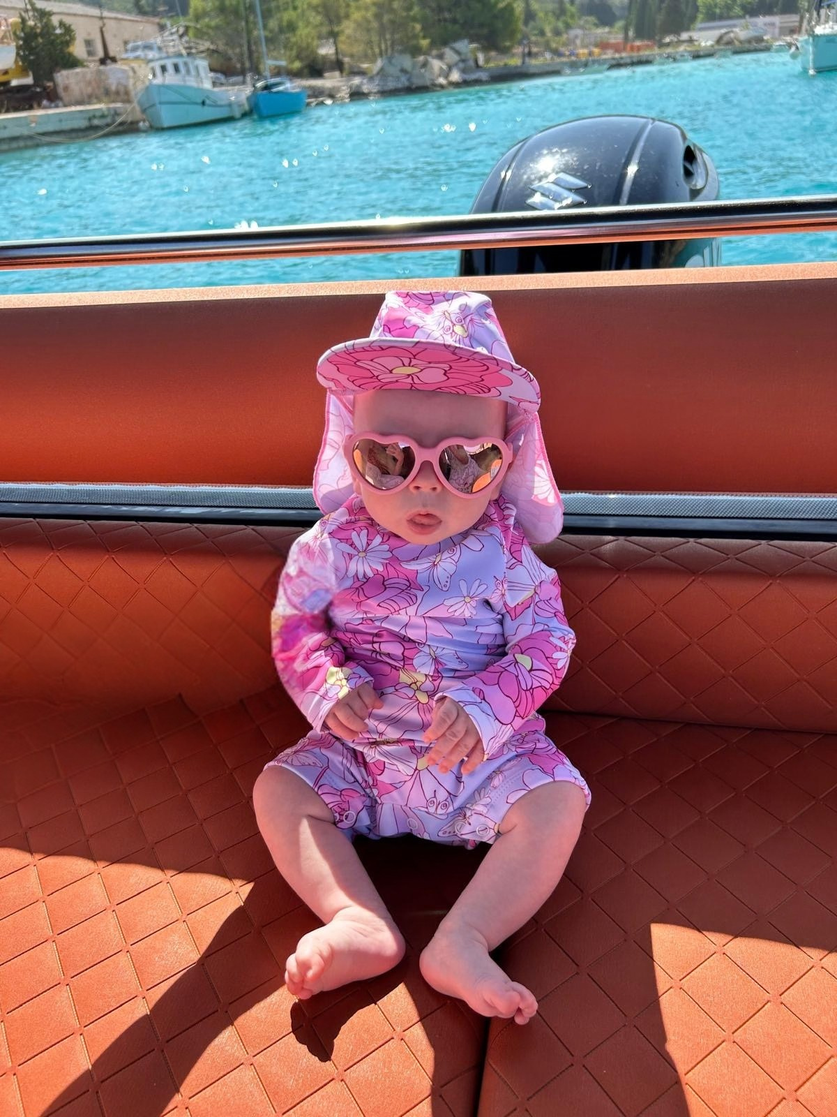 Baby in sunglasses on a speedboat.