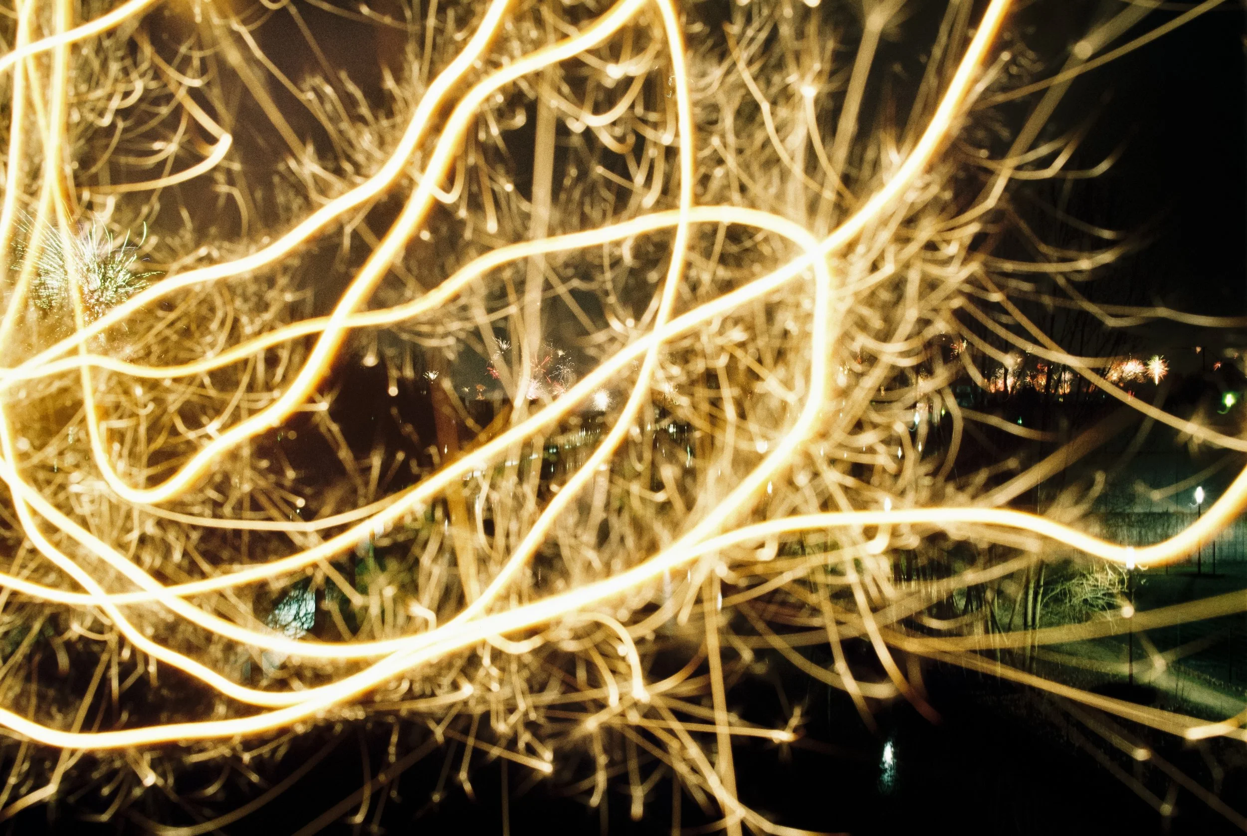 Lichter, die in einer Nahaufnahme in der Dunkelheit wirbeln, mit einer verschwommenen Stadt im Hintergrund.