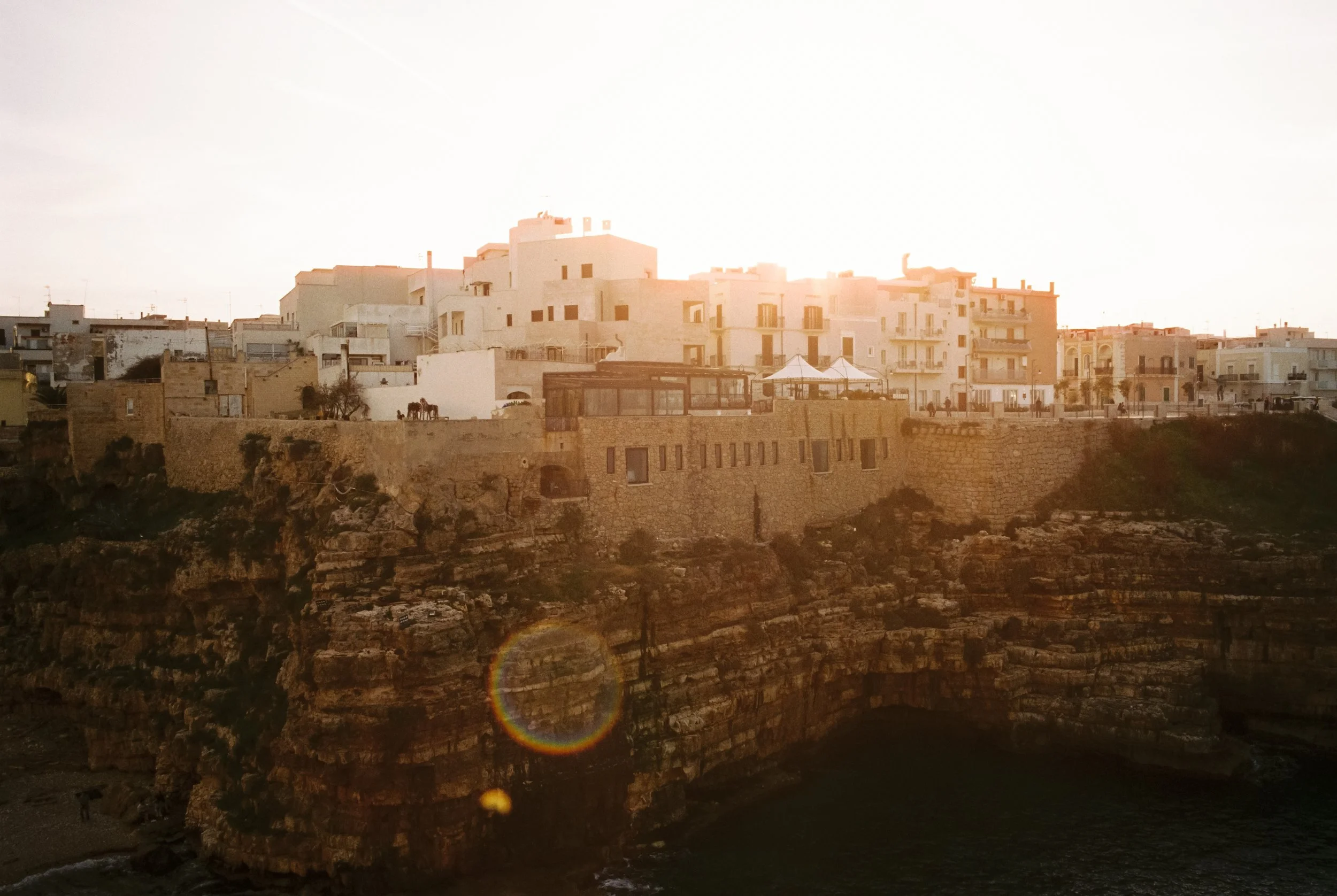 Weiße Gebäude auf Klippen bei Sonnenuntergang