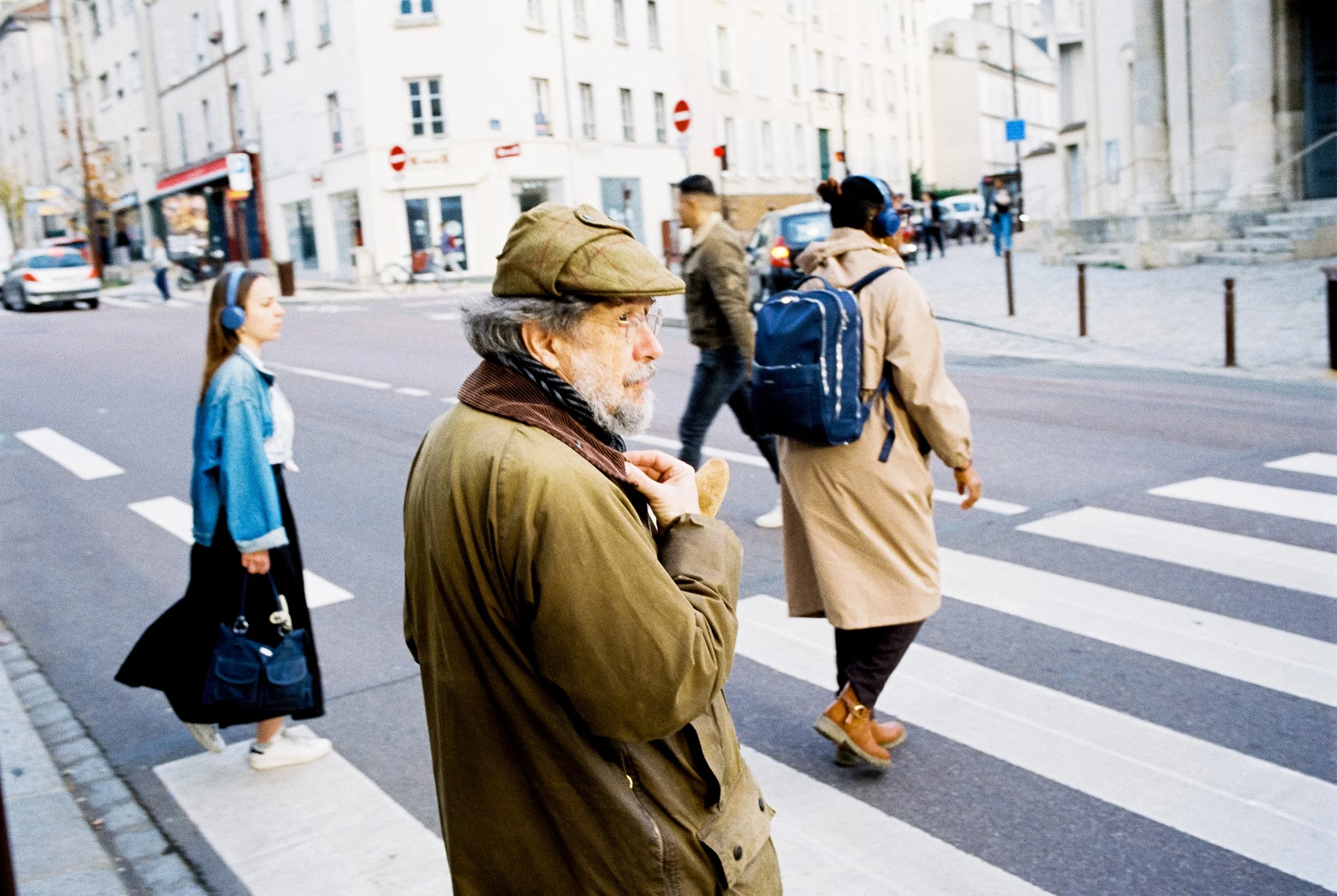 Menschen überqueren eine Straße an einem Zebrastreifen in einer Stadt.