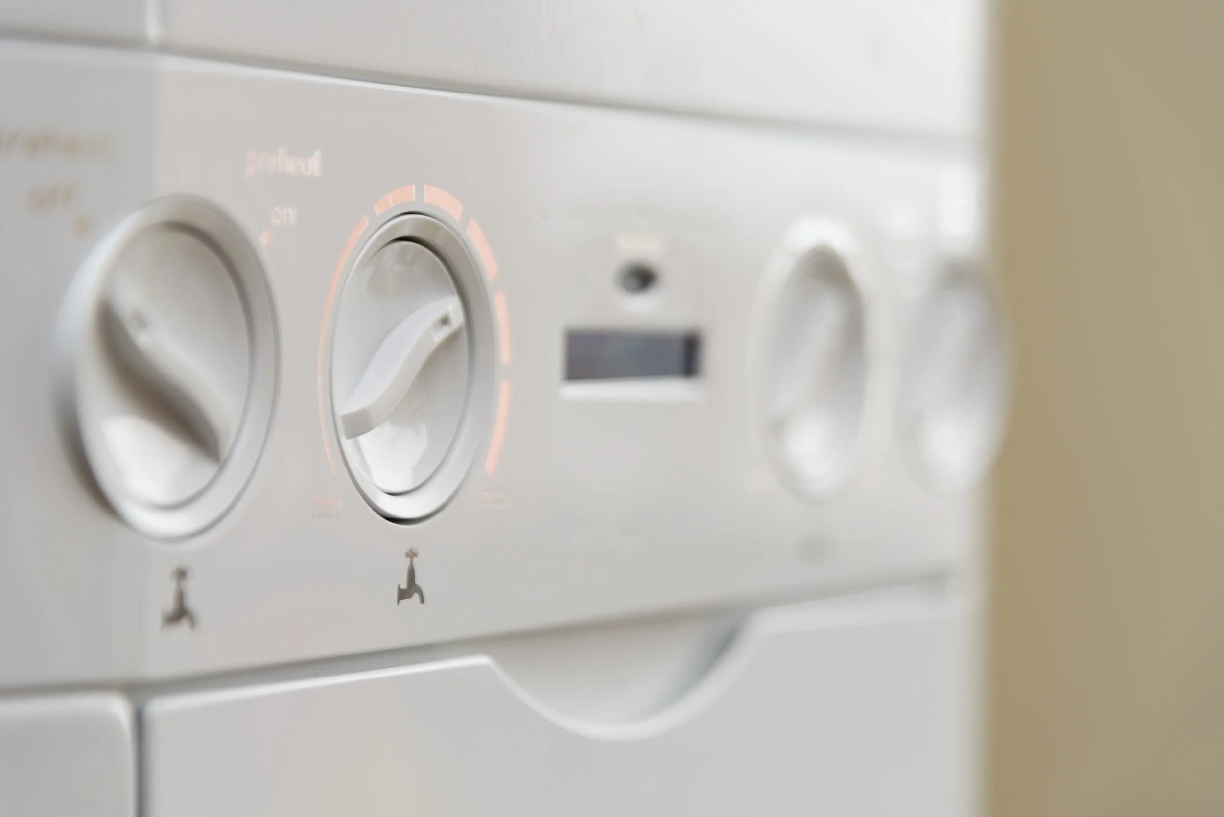 Close-up of a Ideal combi boiler control panel with dials and buttons, one dial set to the 'recommended' setting.