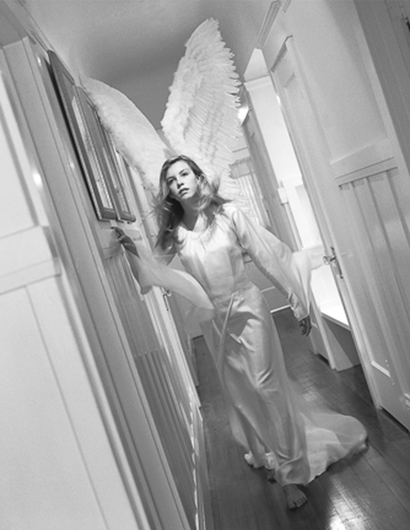 Savior by Kerry Swank featuring an angelic figure walking through a quiet hallway, symbolizing faith, protection, spiritual guidance, healing, hope, and God’s comforting presence through life’s journey.