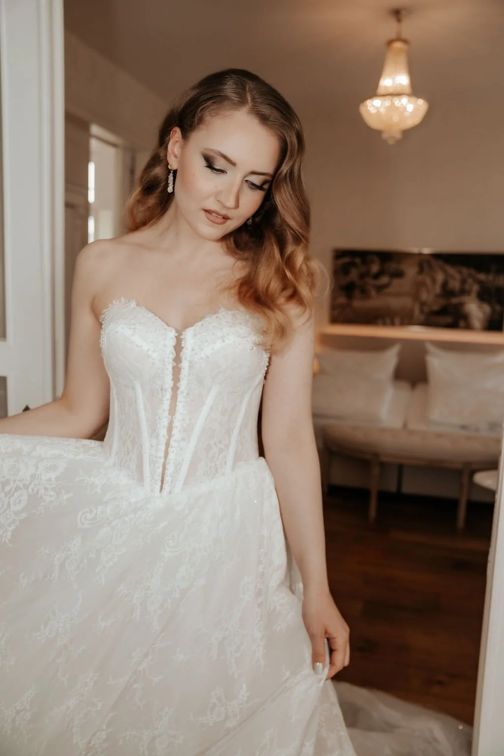 Braut in Hochzeitskleid schaut sich im Spiegel an.