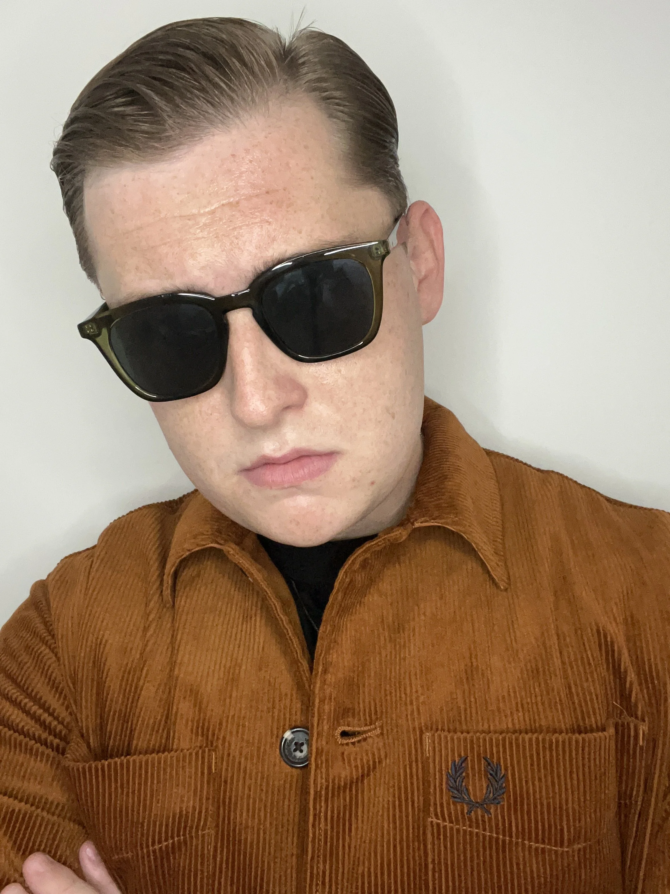 comedy poet wearing fred perry jacket and sunglasses