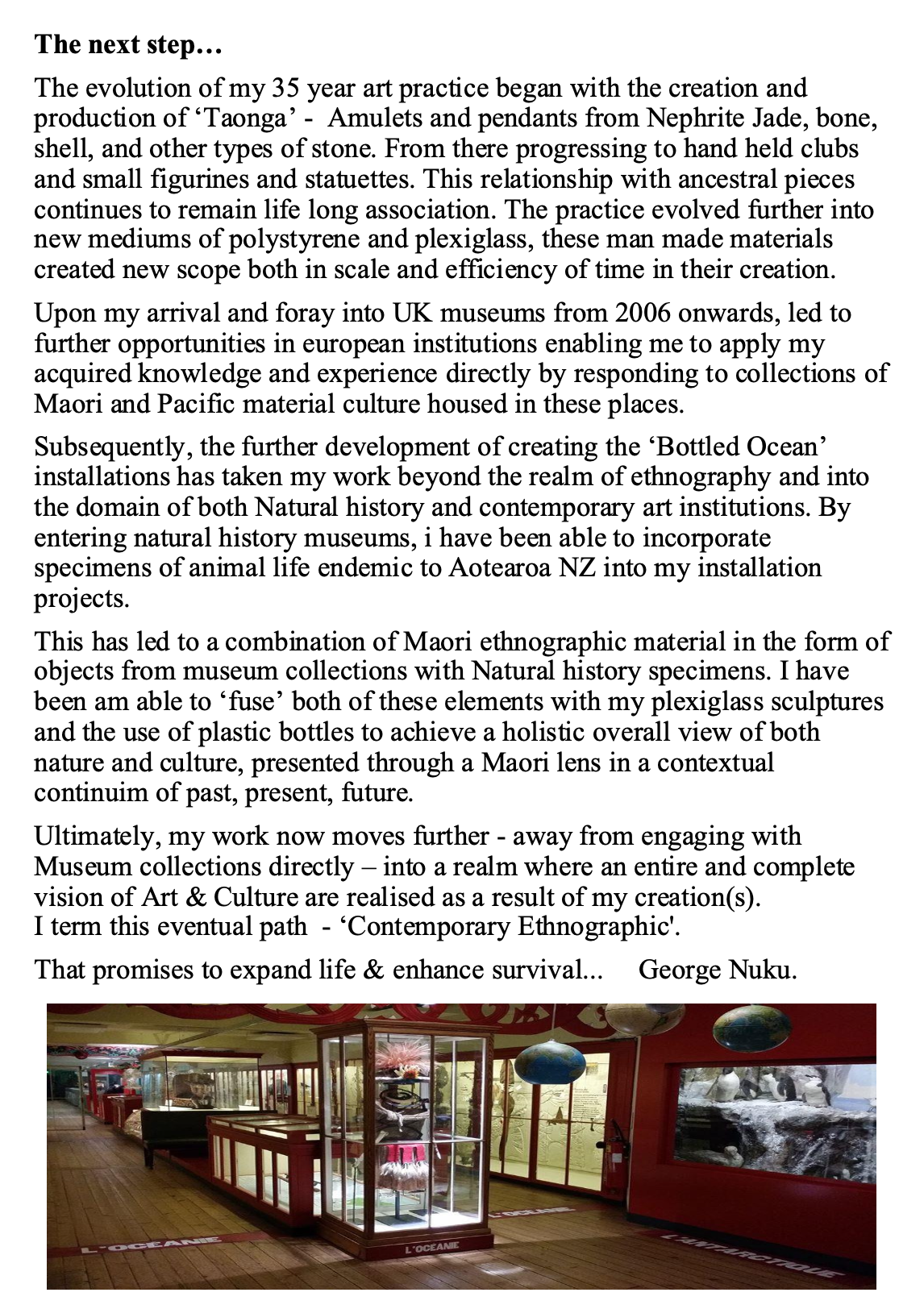 Interior view of a museum exhibit with display cases containing sculptures and artifacts, and a large aquarium or tank on the right side with water and rocks.