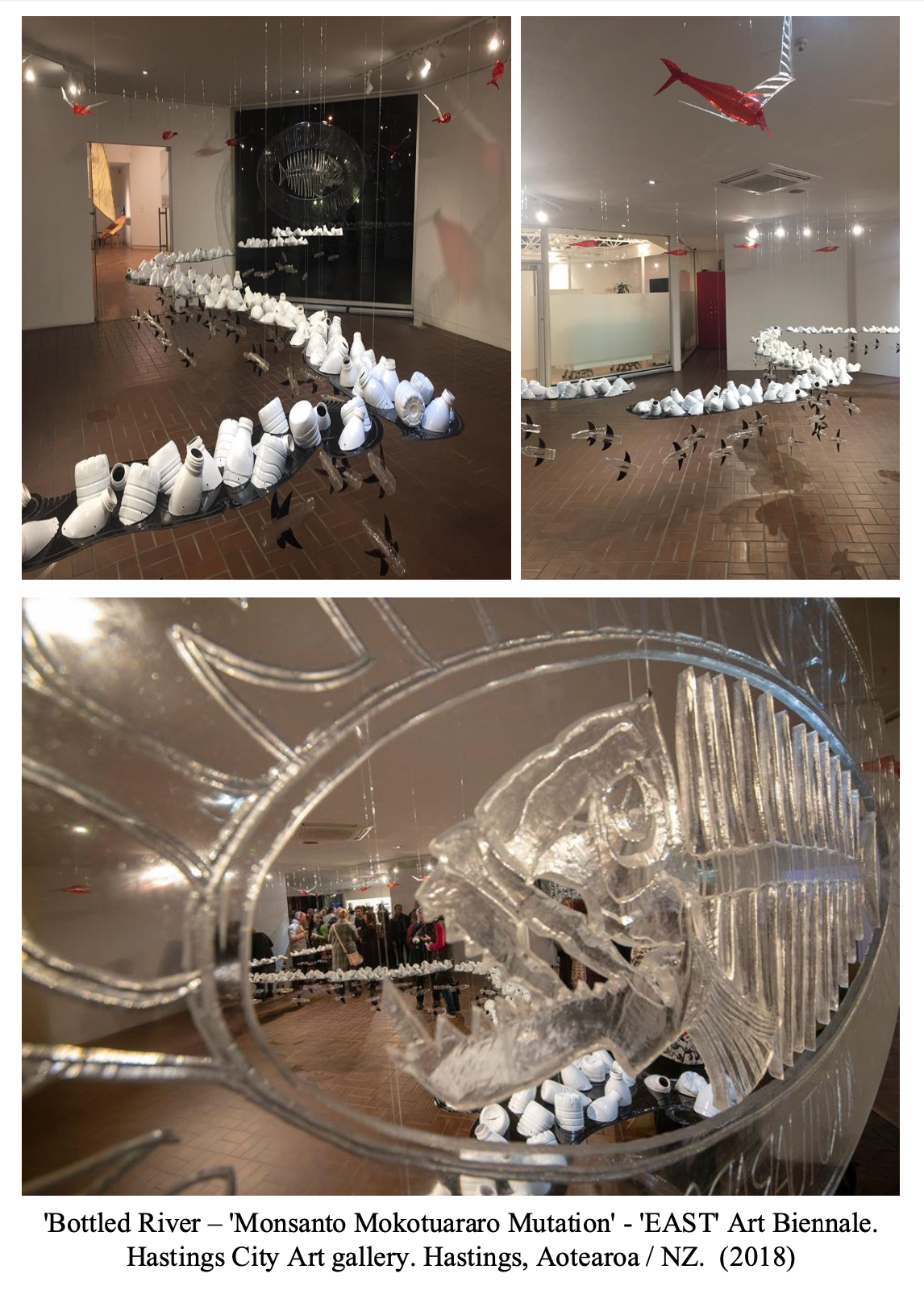 Art installation titled 'Bottled River - Monsanto Mokotuaro Mutation' at the EAST Art Biennale in Hastings City Art Gallery, Hastings, New Zealand, 2018. Features a winding river of white bottles with suspended origami fish, and a close-up of a detailed glass sculpture of a fish's head.