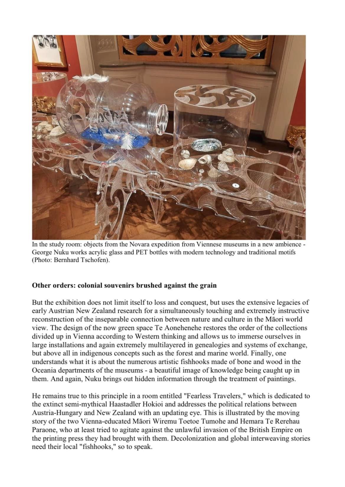 Display of acrylic glass and PET bottles filled with shells and decorative objects, arranged on a transparent, curvy table, with intricate woodwork and framed pictures visible in the background.