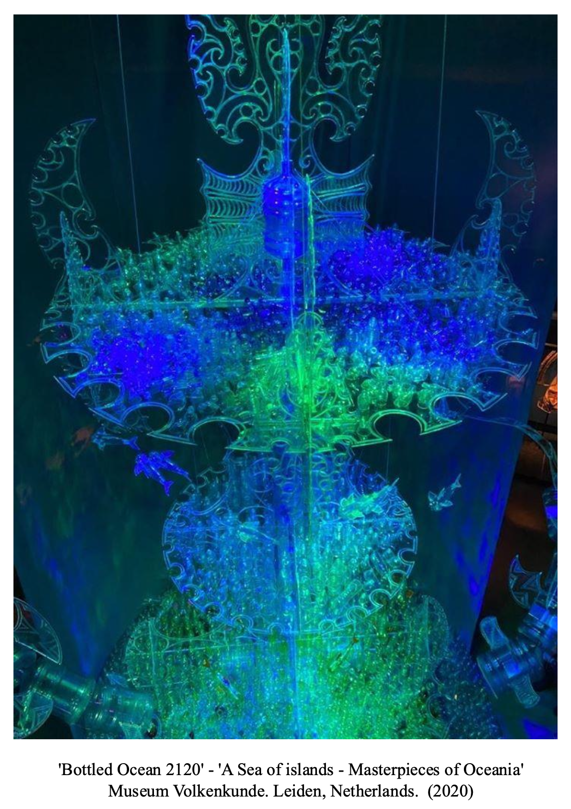 Colorful illuminated art installation titled 'Bottled Ocean 2120' depicting a sea of islands with intricate, glowing patterns in blue, green, and yellow at the Museum Volkenkunde in Leiden, Netherlands, 2020.
