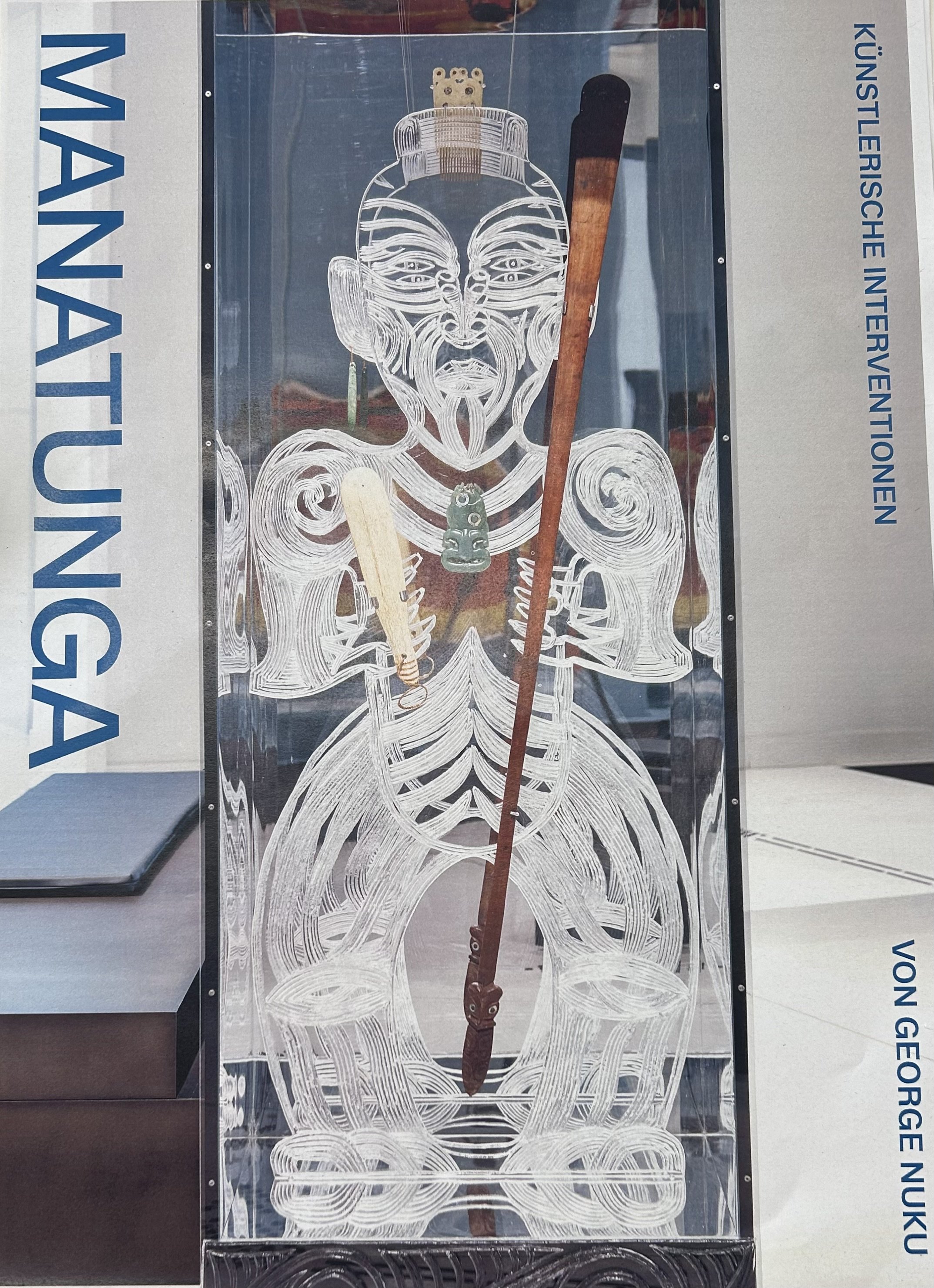 An ice sculpture of a mythological figure holding a wooden staff. The sculpture is detailed and is displayed at the Kunstlerishe Interventonen exhibition in Mana Tongga.