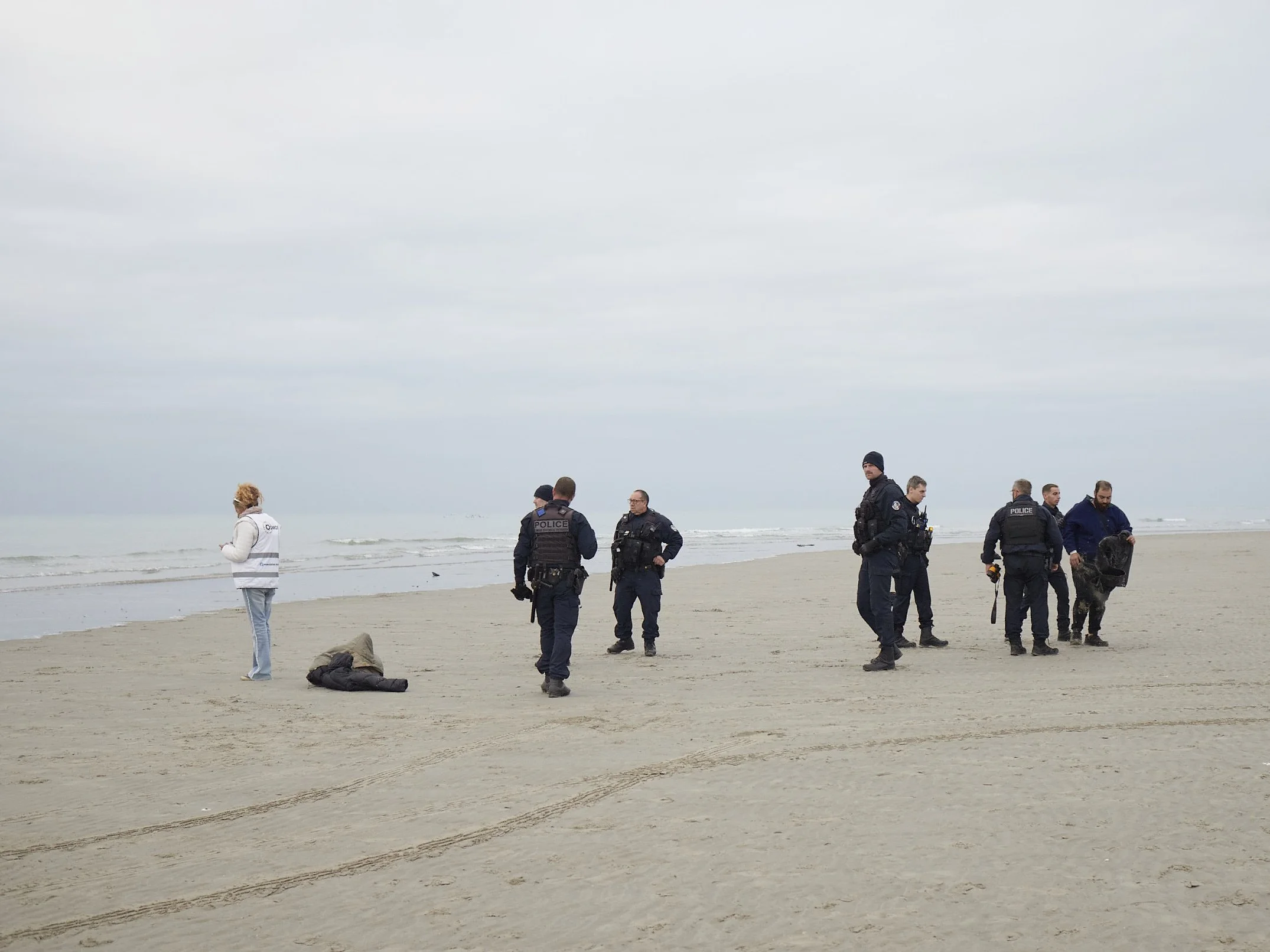 © Zélie Hallosserie, Departure. Police men and a volunteer after the departure of a small boat