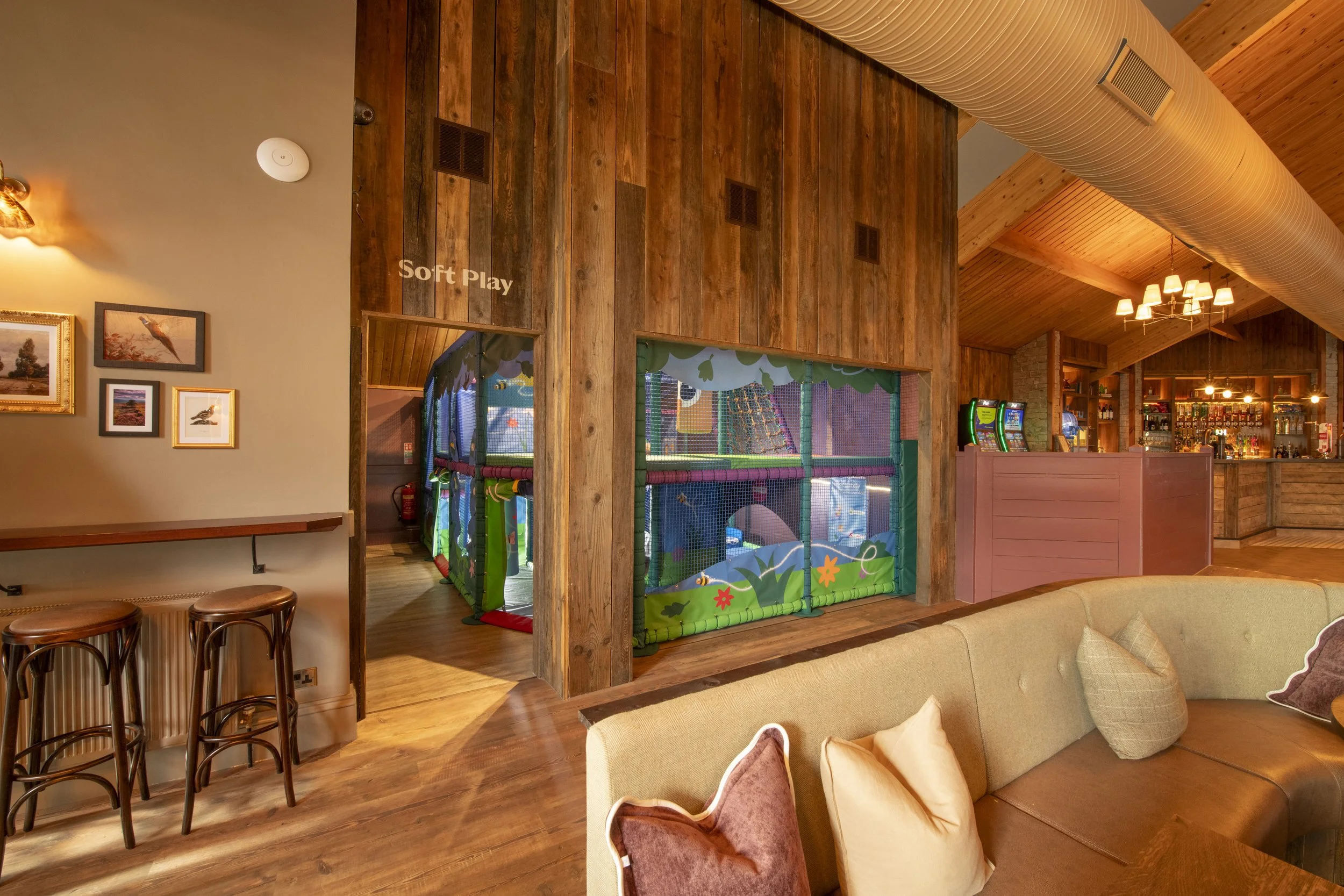 Family of five enjoying a meal at a cozy restaurant with wooden accents and large windows.
