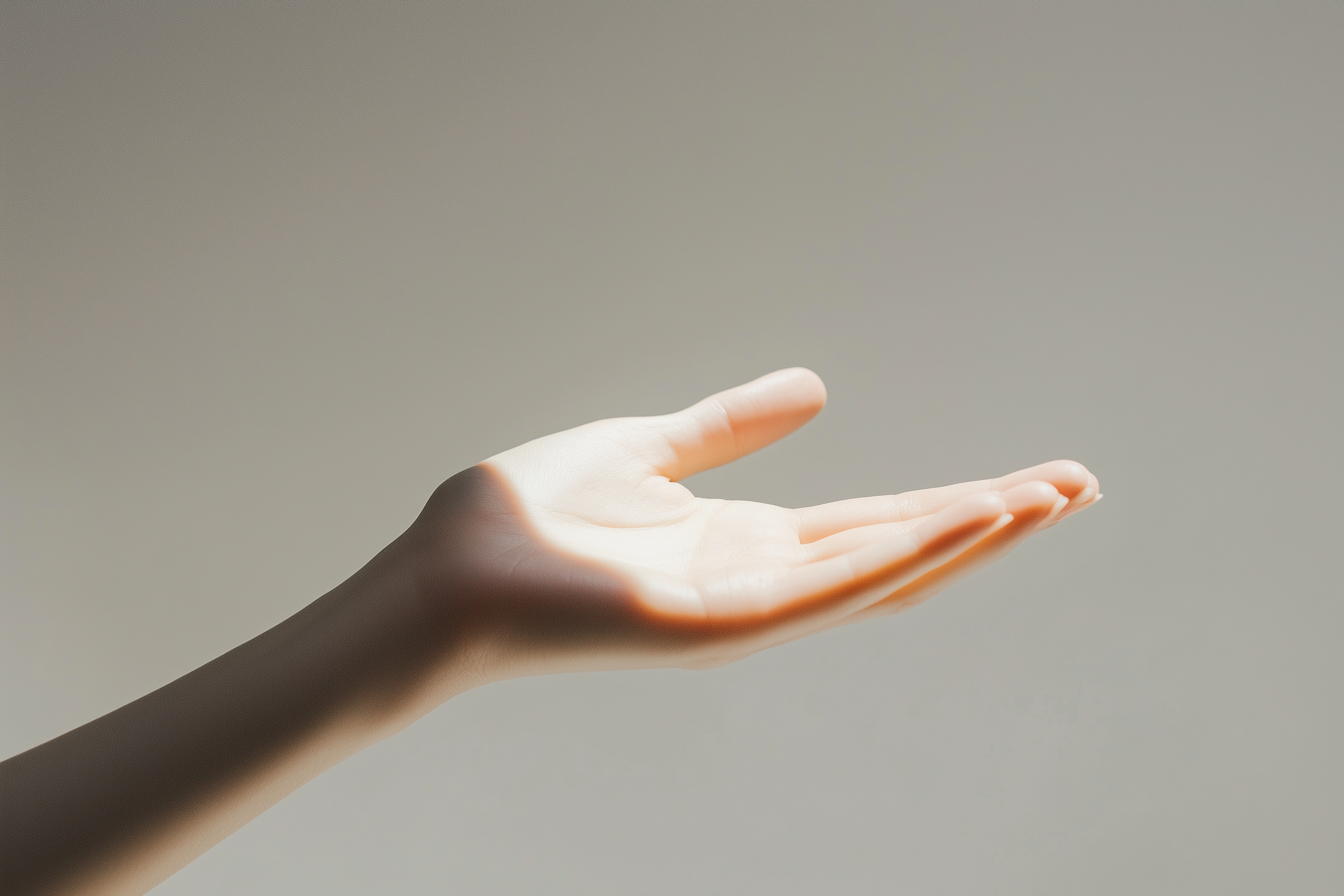 En palme med fingrene let løftet, bortset fra tommelfingeren, mod en neutral baggrund.