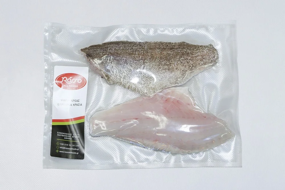 Vacuum-sealed package of two fish fillets, one with skin and one without, on a white background.
