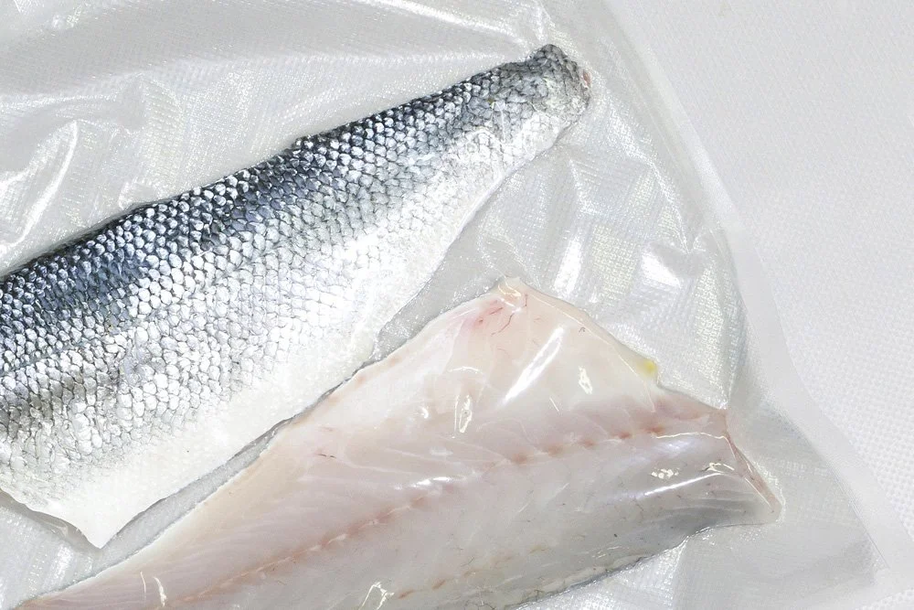 Fresh fish fillet and whole fish on a plastic surface