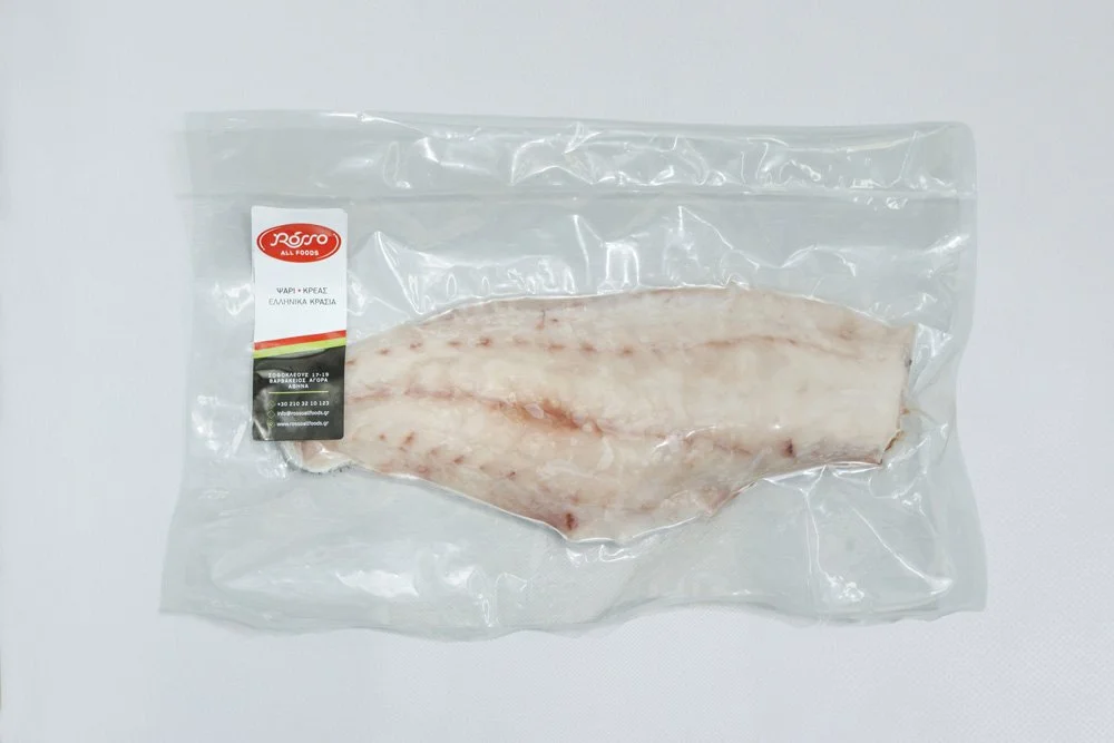 Frozen fish fillet in clear plastic packaging with a label.