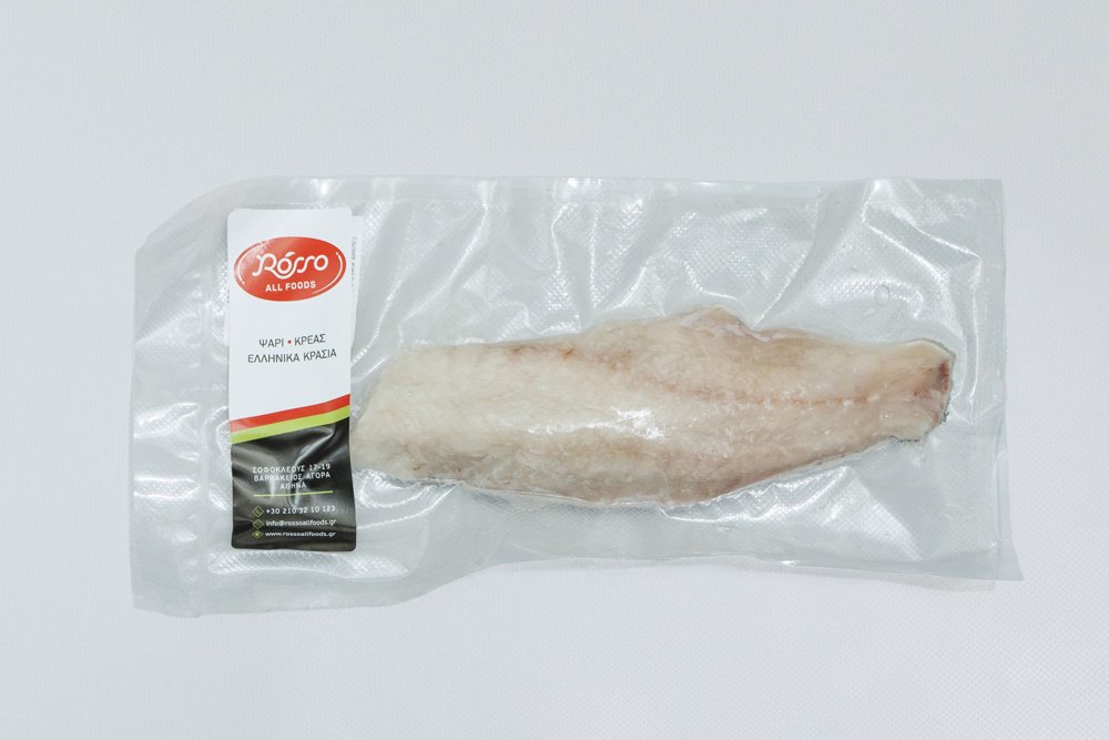 Frozen fish fillet in vacuum packaging on a white surface.