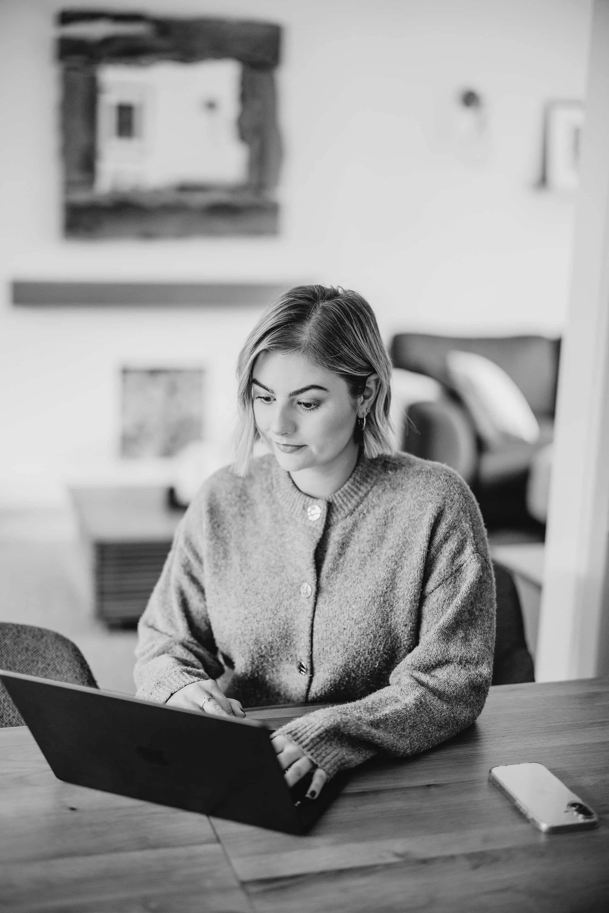 Bespoke Website Design by Ellie from Elevo Marketing, working at her laptop at a table.