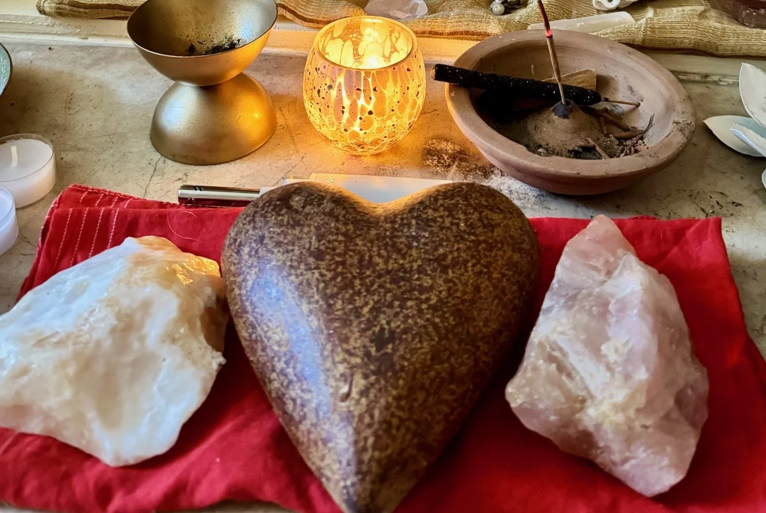Heart-shaped stone altar with crystals, selenite, candlelight, and sacred objects symbolizing healing, connection, transformation, and love.