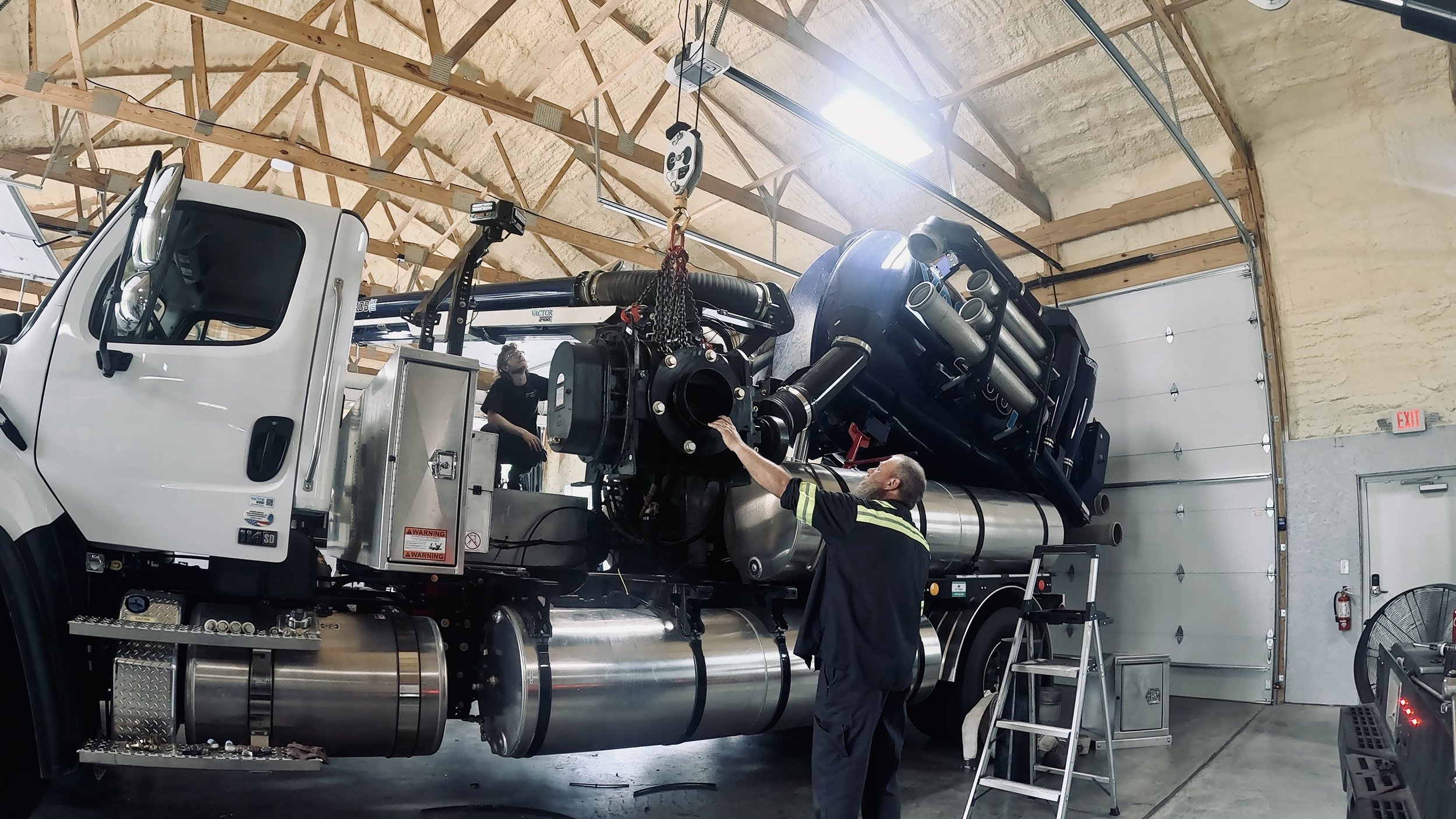 Service technicians replacing a blower on a vac truck at the 502 Equipment Service center near Louisville, Kentucky.