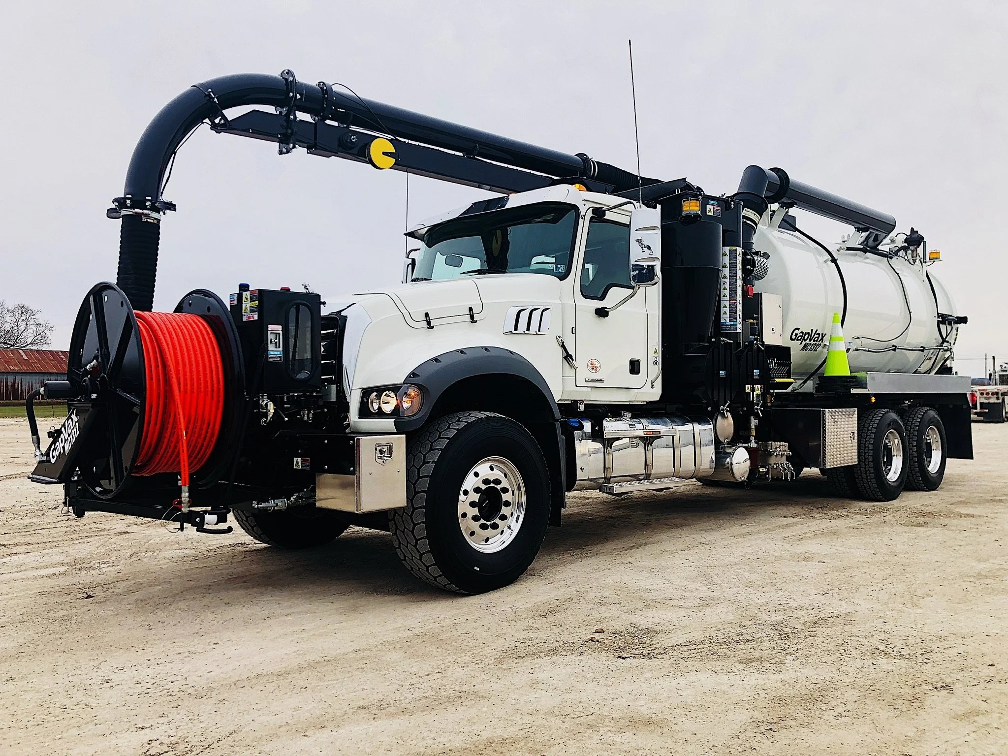 A large white GapVax MC vacuum truck with black hose reel and orange hose parked on a gravel lot in LaGrange, KY ready to be the next vac truck rental.
