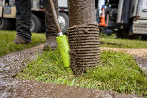 A close up of a machete hydro excavation nozzle getting ready to dig in the grass with the help of a vacuum truck boom. 
